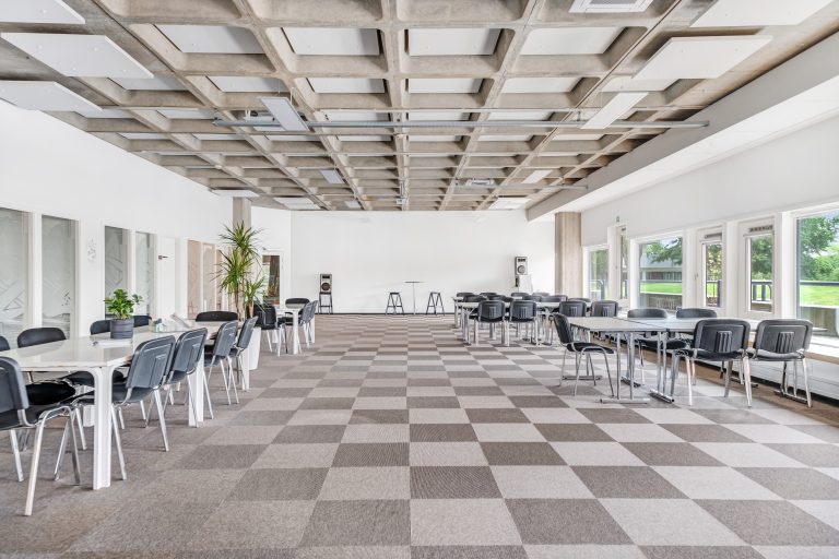 Bright office unit 2.04 with tables, chairs and windows facing greenery