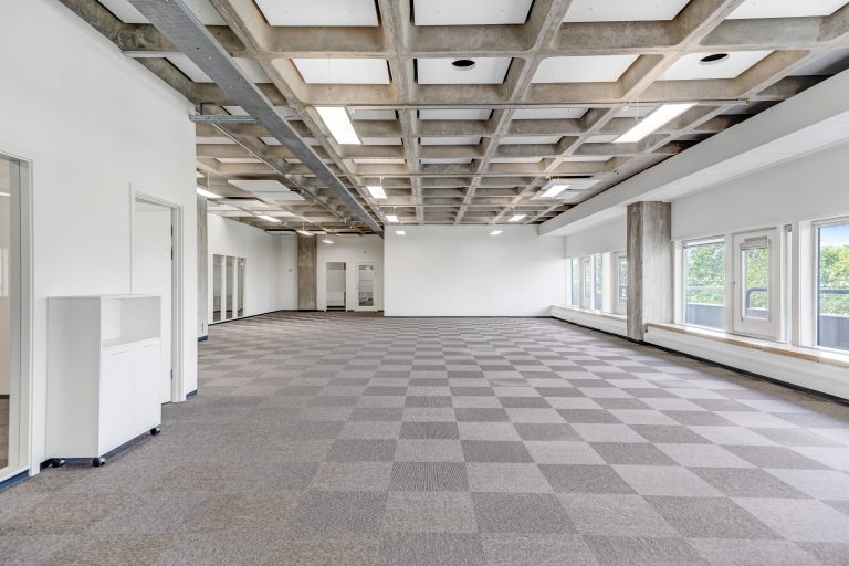 Empty, bright office unit 4.03 with carpet and windows along its length
