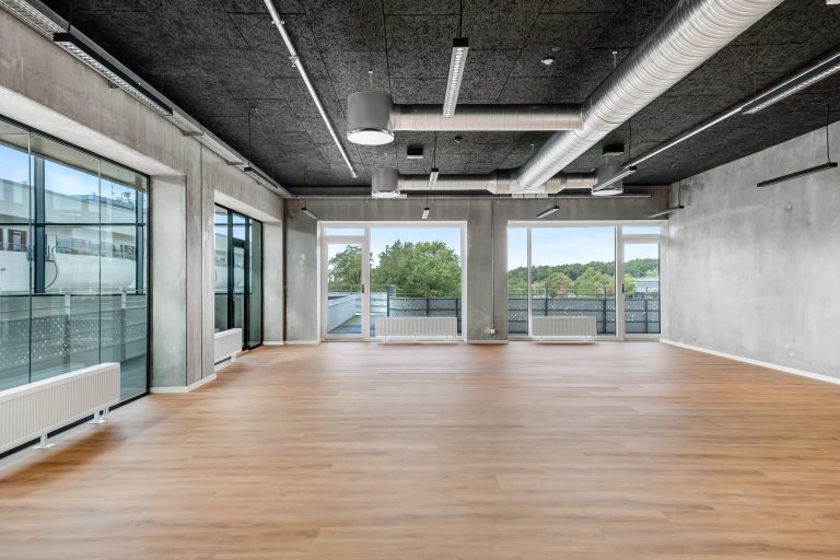 Empty, bright office unit H1.1 with large windows and wooden floor in the high-rise