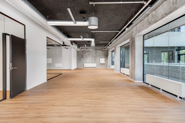 Vacant office unit H1.1 with wooden floor and glass facade