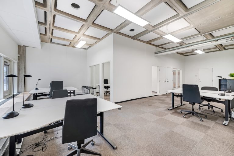 Office unit 1.07-5 with sit-stand desks and office chairs under a coffered ceiling