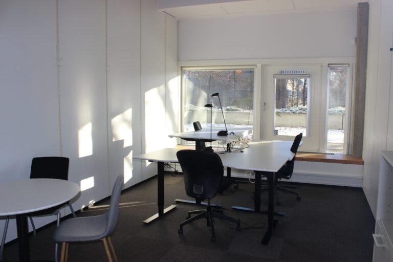 Three-person office with desks, lamps and a round table