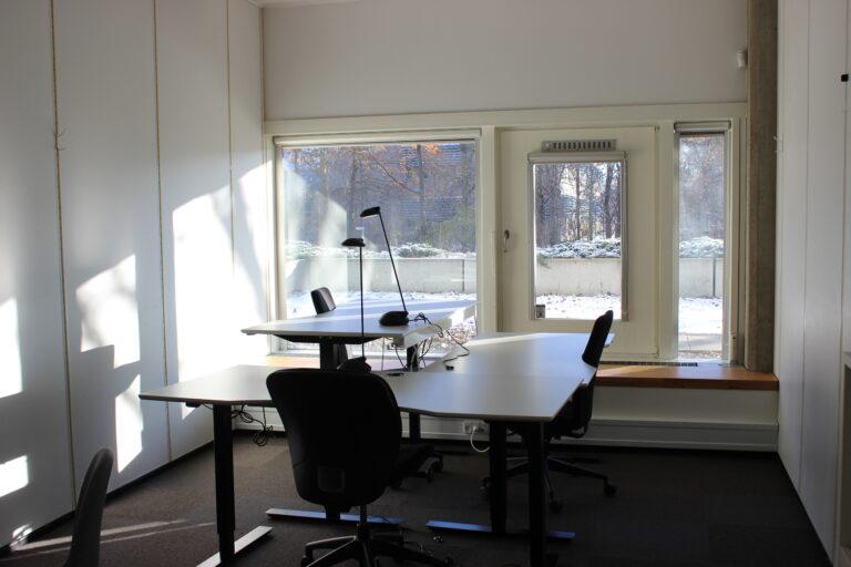 Office with desks and a view of green surroundings